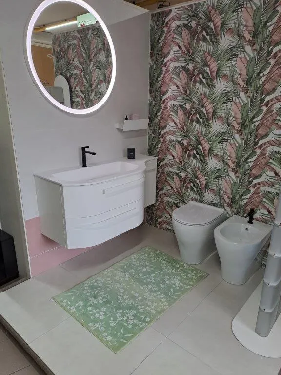 Mobile bagno bianco curvo con specchio tondo e rivestimento a motivo tropicale