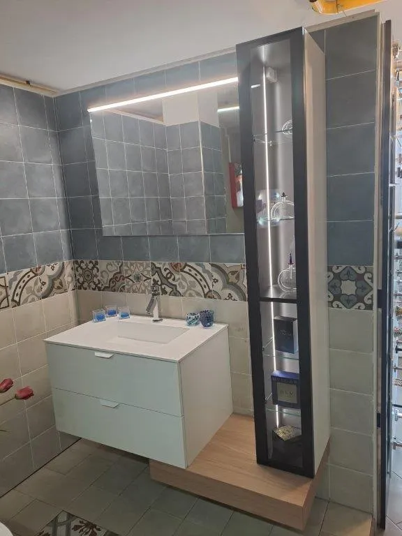 Mobile bianco con colonna nera, fascia decorativa e rivestimento grigio