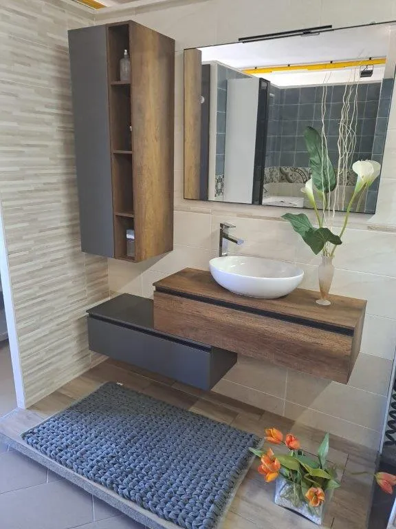 Mobile in legno con lavabo da appoggio bianco e pensile a colonna