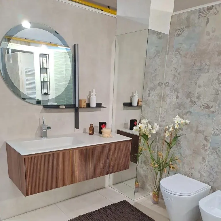 Mobile sospeso in noce con top bianco, specchio tondo e rivestimento effetto pietra